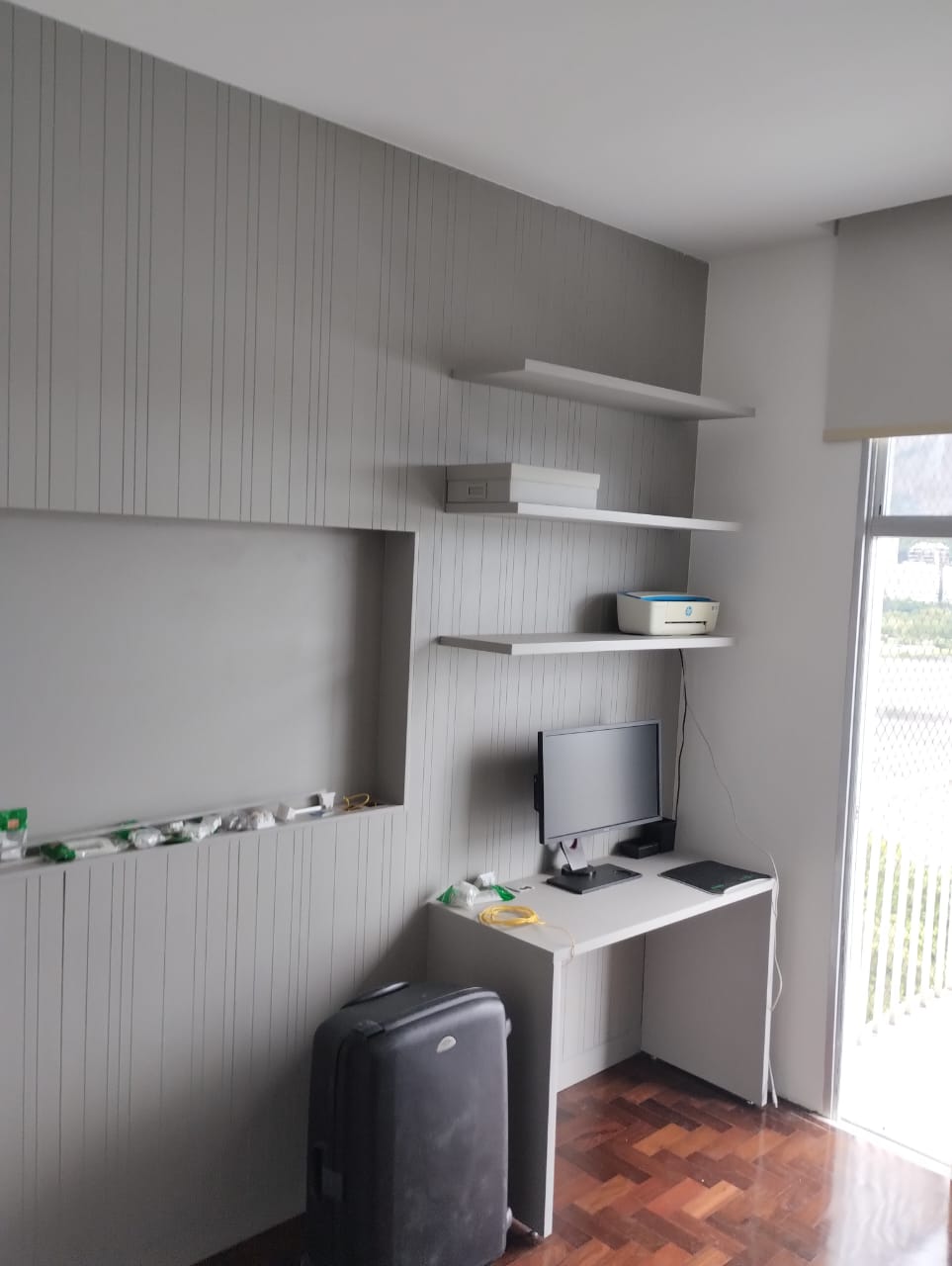 Home office planejado com prateleiras e nicho iluminado